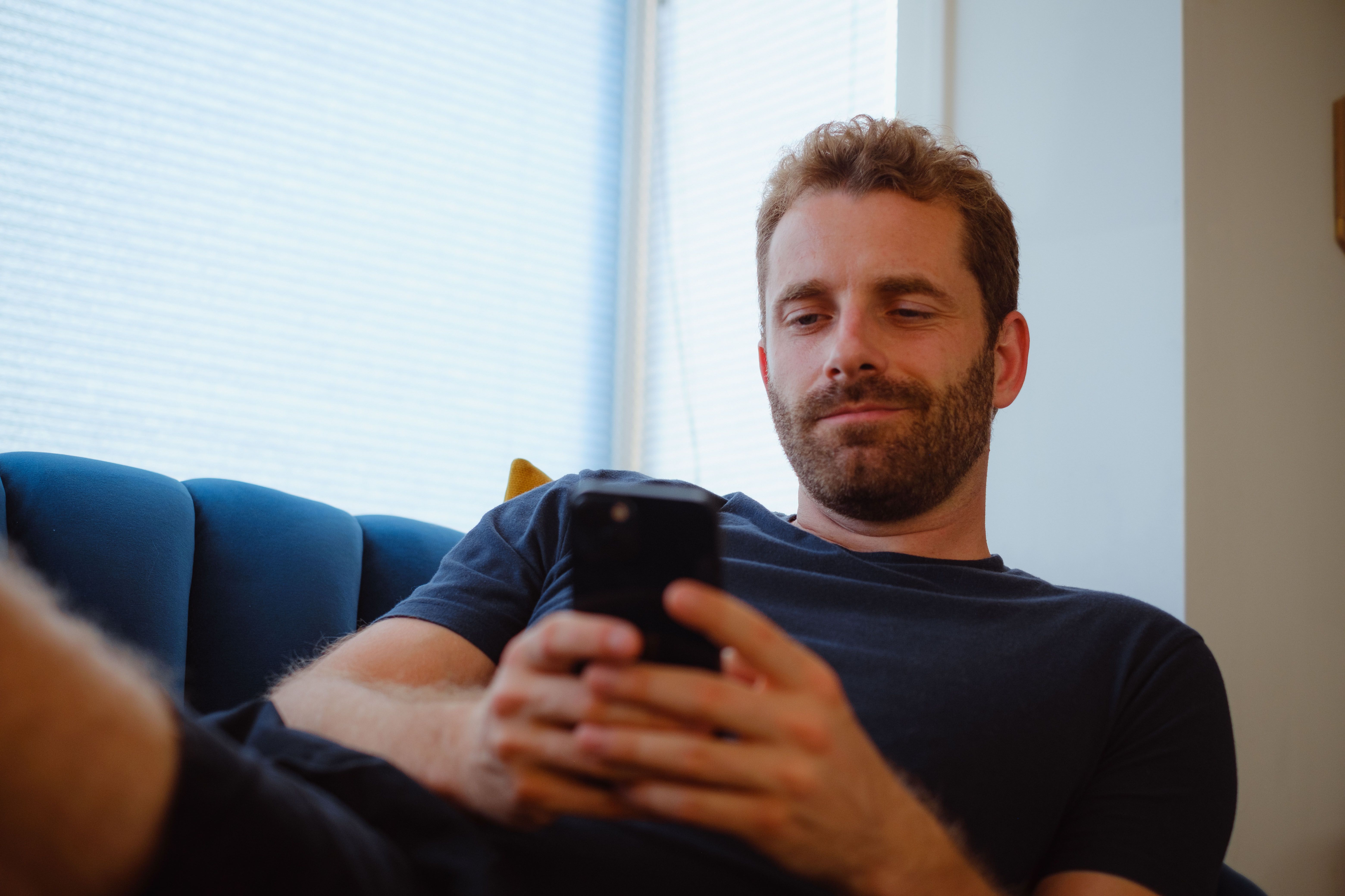 Blije klant van Sunergy met telefoon in zijn handen